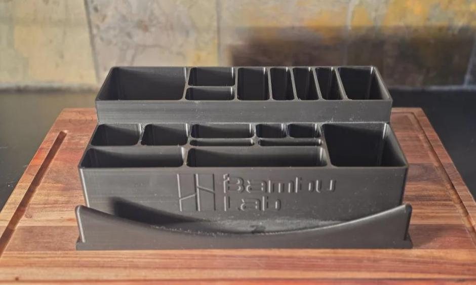 Black 3D-printed Bambu Lab tool and build-plate organizer on a wood surface